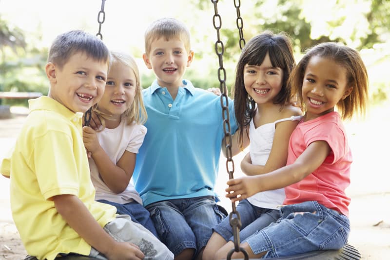 A group of children sitting on a swing